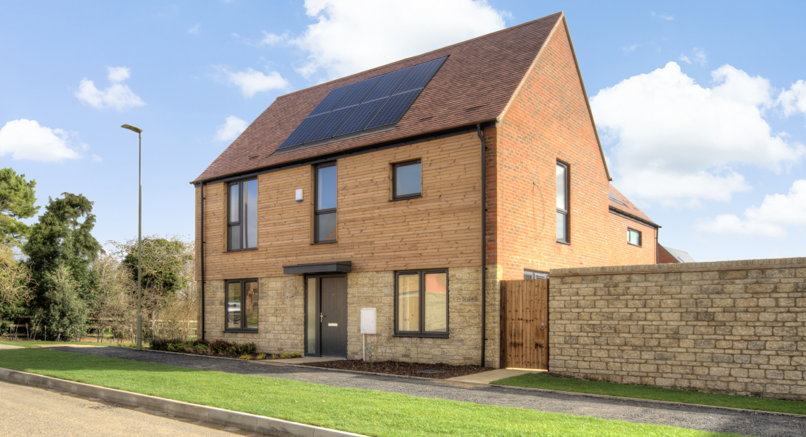 Brick, stone and timber-clad home at Church Farm with roof solar panels and tall windows