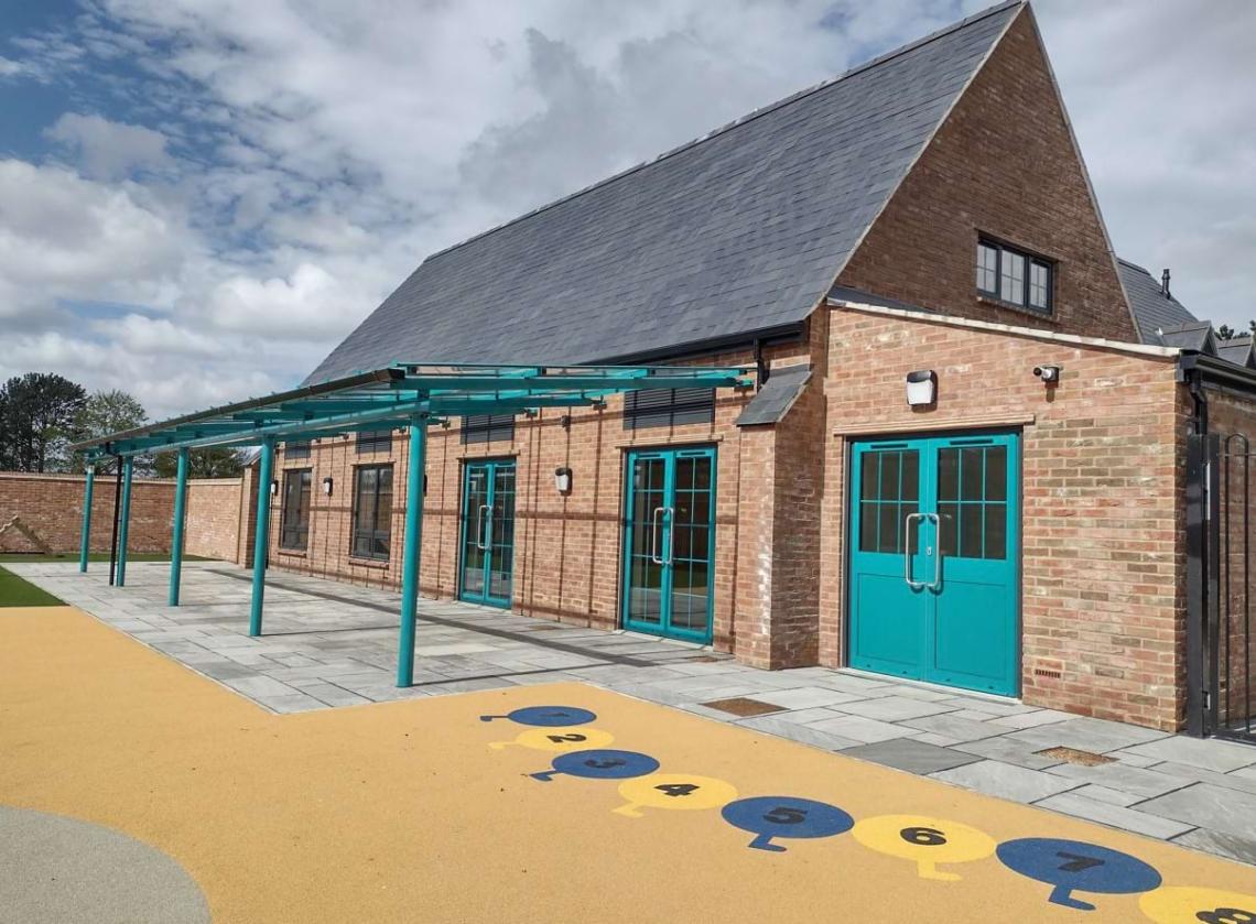 Park View childcare nursery building with teal doors and a play area