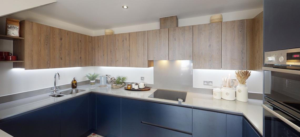 Fitted kitchen with navy base units, wood-effect wall cabinets and grey worktops