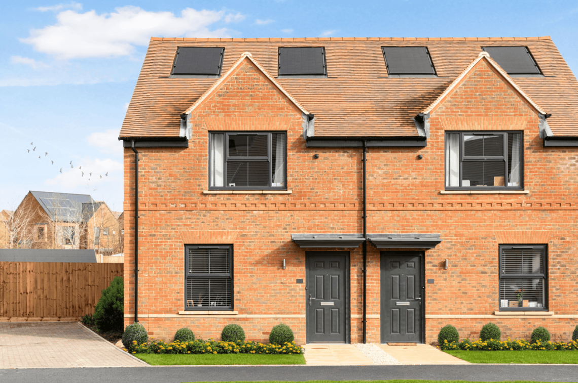 Pair of red-brick semi-detached homes with grey front doors and roof solar panels